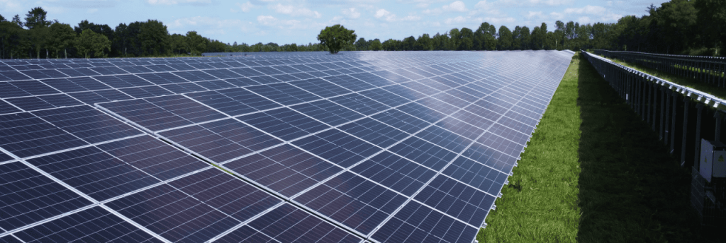 Nahaufnahme des Solarparks Kleibrok mit endlosen Reihen flacher Solarmodule auf Gr&uuml;nfl&auml;che.